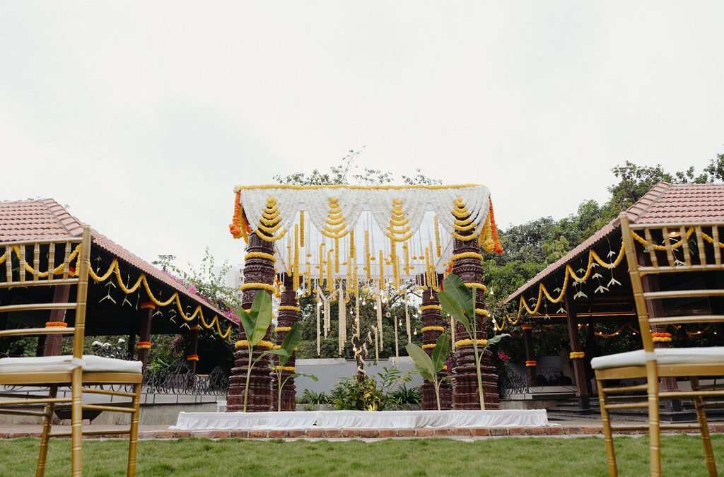 Outdoor wedding mandap decorated with white and yellow flowers at The Lily Pond in East Bangalore